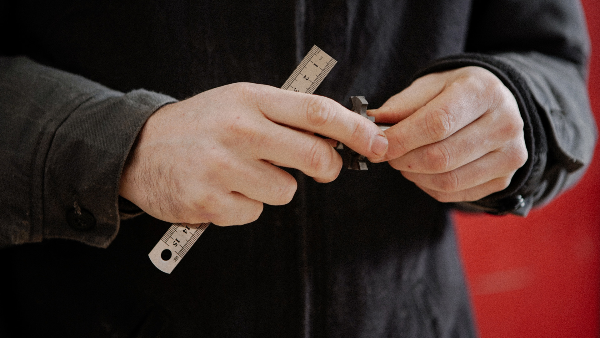 Person holding ruler and chuck with navy top